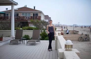 Rockaway broker Lisa Jackson standing on the deck of one of her listings, a $2.999 million beachfront home in Belle Harbor. >